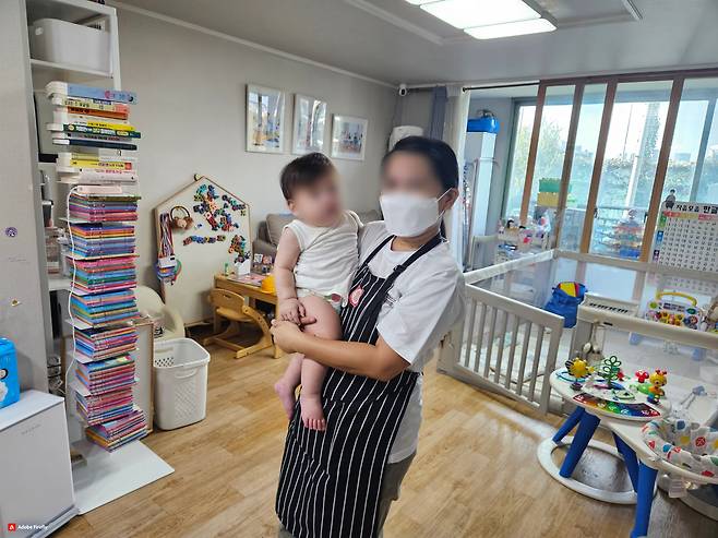 A Filipina caregiver holds an infant at a home in Seoul. (Seoul Metropolitan Government)