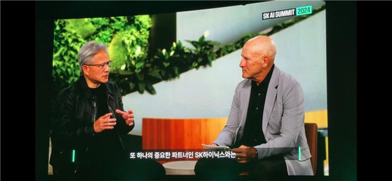 Nvidia's Jensen Huang, left, speaks about the importance of high bandwidth memory (HBM) chips in the AI ecosystem in an interview clip released by SK at the SK AI Summit 2024 held at Coex, southern Seoul, on Monday. [LEE HEE-KWON]