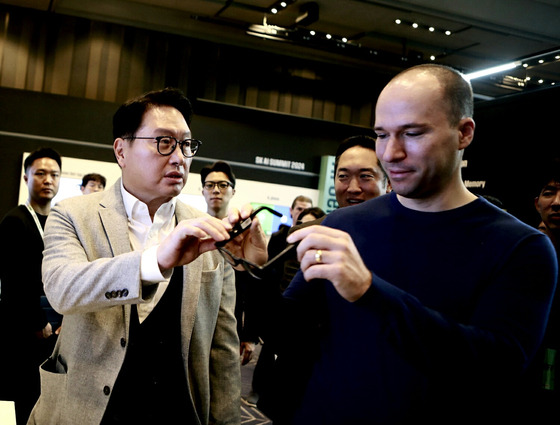 SK Chairman Chey Tae-won, left, and OpenAI CEO Greg Brockman at one of the booths set up for the SK AI Summit 2024 held in southern Seoul on Monday.[SK]