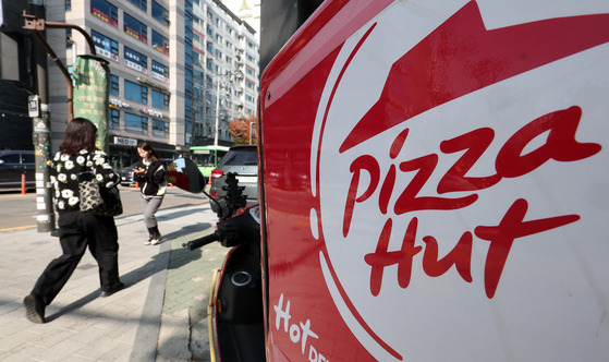 A passerby walks by a Pizza Hut store in Seoul on Tuesday. [NEWS1]