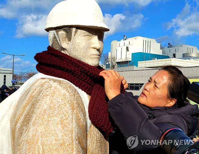 "우리 아들, 얼마나 추울까" 충남 태안화력발전소 앞에서 어머니 김미숙 씨가 아들의 동상에 목도리를 둘러 주고 있다. 
[연합뉴스 사진]