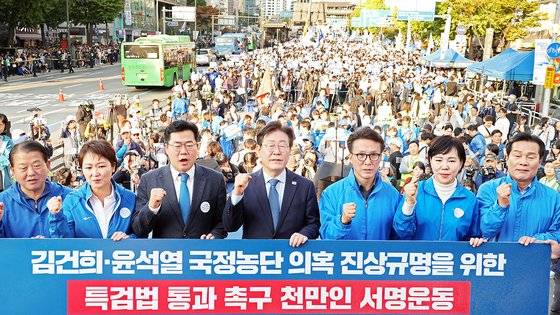 이재명 더불어민주당 대표가 2일 오후 서울 중구 서울역 인근에서 열린 ‘김건희 국정농단 범국민 규탄대회’에서 박찬대 원내대표를 비롯한 주요 참석자들과 함께 김건희?윤석열 국정농단 의혹 진상규명을 위한 특검법 통과 촉구 천만인 서명운동판에 서명한 뒤 기념촬영하고 있다. 뉴스1