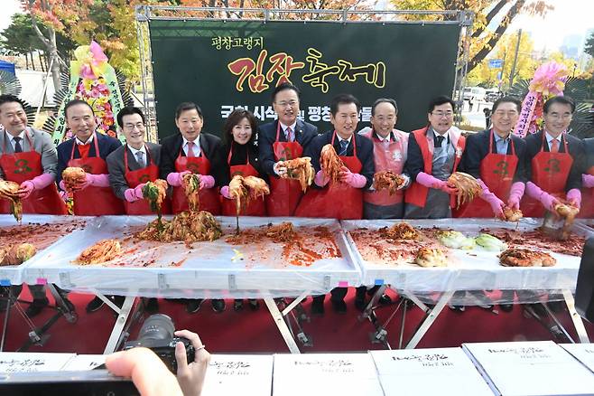 추경호 국민의힘 원내대표와 박찬대 더불어민주당 원내대표를 비롯한 의원들이 5일 서울 여의도 국회의사당 소통관 앞 광장에서 열린 제7회 평창고랭지김장축제 시식회 및 평창농산물전에서 김장을 하고 있다. [평창고랭지김장축제위원회 제공]