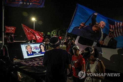 마러라고 리조트 근처에 모인 트럼프 지지자들 (미국 플로리다주 팜비치 AFP=연합뉴스) 2024년 11월 5일(현지시간) 미국 대통령선거가 치러진 가운데 공화당 후보로 출마한 도널드 트럼프 전 대통령의 마러라고 리조트 근처에 지지자들이 모여 개표상황 중계를 보고 있다.  (Photo by Giorgio Viera / AFP) 2024.11.6.