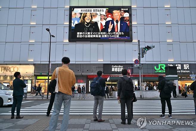 미국 대선 뉴스 보는 일본인 (도쿄 AFP=연합뉴스) 6일 일본 도쿄 이케부쿠로역 인근 횡단보도에서 사람들이 미국 대선 관련 뉴스를 보고 있다.