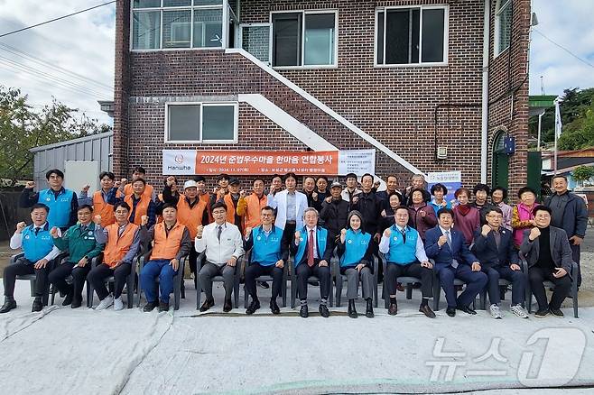 한화솔루션 여수공장은 7일 전남 보성군 벌교읍 낙성리 행정마을에서 '2024 준법우수마을 한마음 연합봉사' 활동을 갖고 단체 기념사진을 찍고 있다.(한화솔루션 제공)2024.11.7/뉴스1