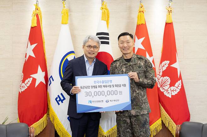 윤희성(왼쪽) 수은 행장이 지난 7일 육군 제5군단 사령부를 방문하여 김성민 군단장에게 후원금을 전달하고 있다