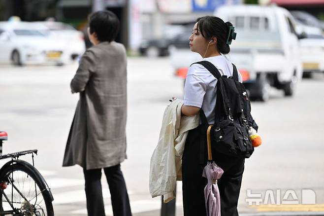 [광주=뉴시스] 이영주 기자 = 광주지역 일교차가 10도 이상으로 예보된 지난9월23일 오전 광주 북구청 사거리에서 한 시민이 겉옷을 챙긴 채 횡단보도 신호를 기다리고 있다. 2024.09.23. leeyj2578@newsis.com