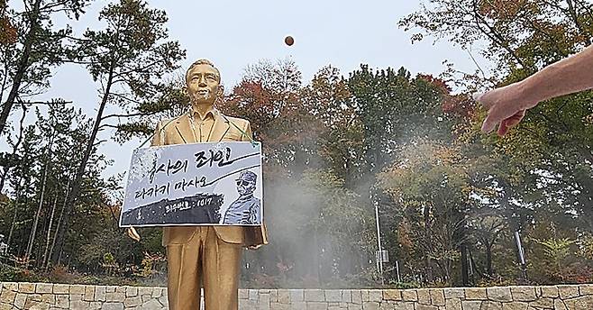 10일 오후 경북 경산시 영남대학교에서 영남대 민주동문회원들이 대학 내 설치된 박정희 동상에 계란을 던지고 있다. 연합뉴스