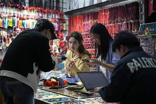 지난 8일 저장성 이우의 도매시장에서 상인들이 아이들과 젊은이들이 좋아하는 제품들을 살펴 보고  있다. AP 뉴시스