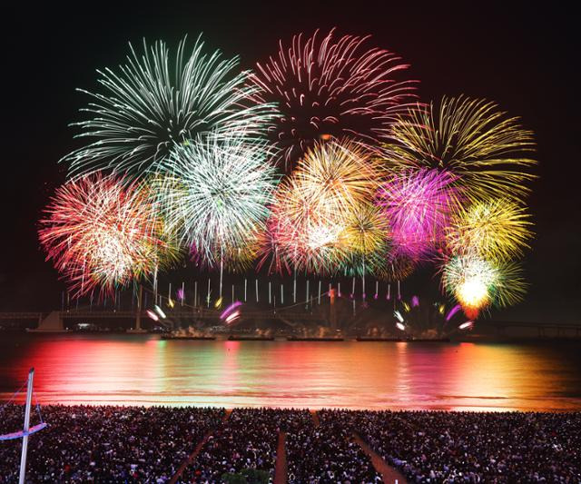 지난 9일 저녁 부산 광안리해수욕장 일대에서 열린 제19회 부산불꽃축제에서 관람객들이 하늘을 수놓은 불꽃을 구경하고 있다. 이날 행사는 사고로 인해 광안대교의 조명이 꺼진 채 진행됐다. 부산=연합뉴스