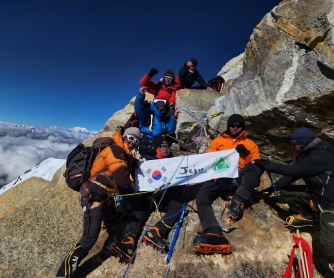 세계 최초로 히말라야 샤르푸5봉에 오른 제주도산악연맹 소속 산악인들이 정상에 제주도 기를 꽂고 환호하고 있다. (제주도산악연맹 제공)