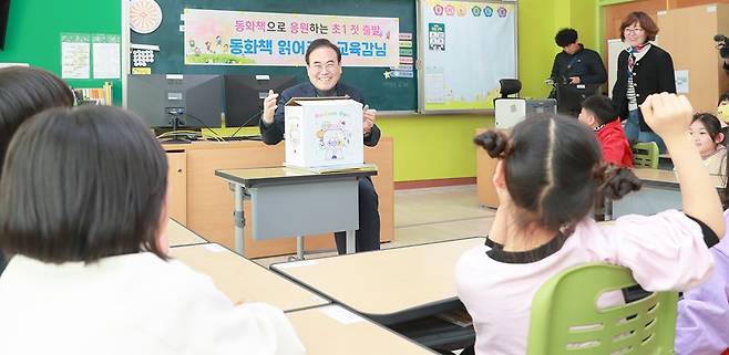 서거석 전북교육감이 전북형 늘봄으로 초등학교를 찾아 1학년 학생들에게 동화책을 읽어주고 있다.  