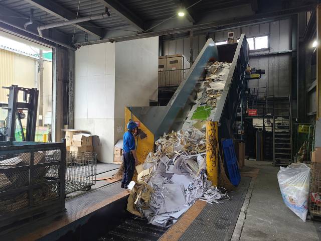 일본 종이 재활용 업체 관계자가 폐지 압축을 위한 작업을 수행하고 있다.