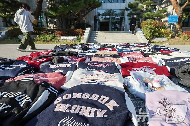 11일 오후 서울 성북구 동덕여자대학교에서 학교 측의 남녀공학 전환 추진에 반발하는 학생들이 항의의 의미로 벗어 놓은 학교 점퍼가 본관 앞을 가득 메우고 있다. 2024.11.11/뉴스1 ⓒ News1 민경석 기자