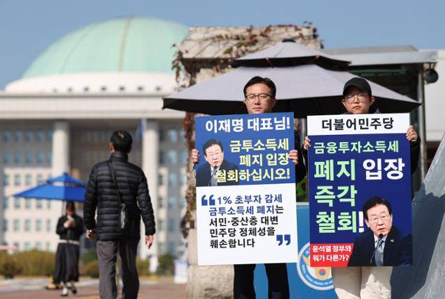 참여연대 조세재정개혁센터 관계자들이 11일 서울 여의도 국회 앞에서 금융투자소득세(금투세) 폐지를 선언한 더불어민주당을 규탄하고 폐지 입장을 철회할 것을 촉구하는 피켓 시위를 하고 있다. 뉴시스