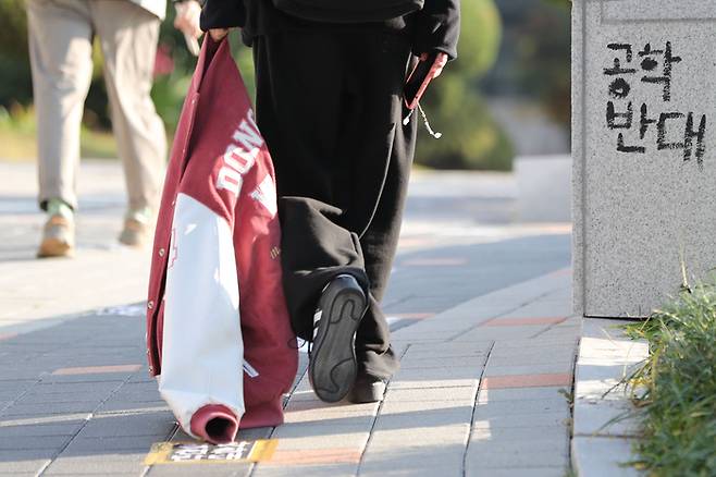 한 학생이 남녀공학 전환 논의에 대해 재학생들이 반발 중인 서울 성북구 동덕여자대학교에서 항의의 의미로 학교 잠바를 본관에 두기 위해 발걸음을 옮기고 있다. 한수빈 기자