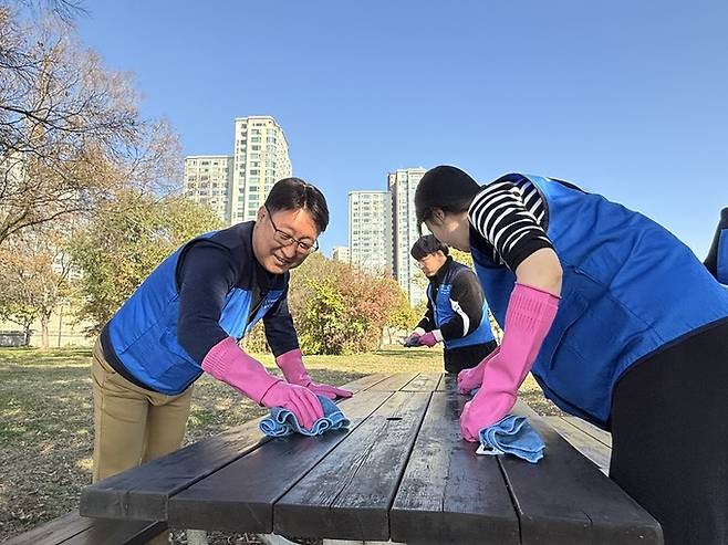 코레일네트웍스 대표이사 전찬호(좌)가 직원들과 이촌한강공원의 체육 시설물 정비활동을 하고 있다.