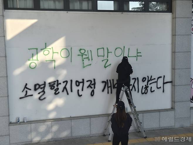 학생들이 학교 곳곳에 락커로 남녀 공학 전환 반대 메시지를 쓰고 있다. 김도윤 기자.