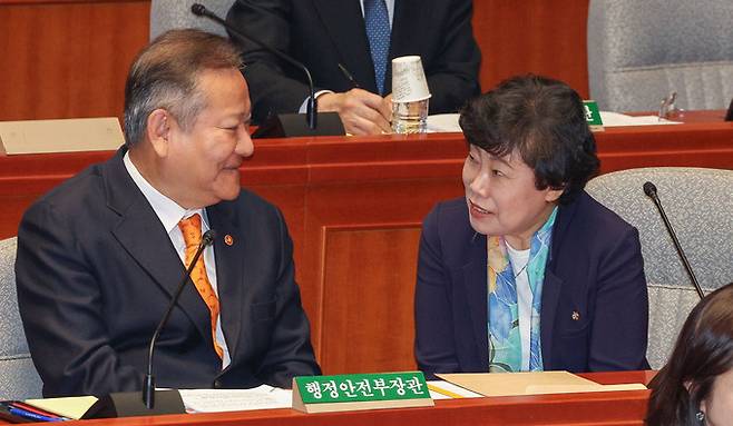 이상민 행정안전부 장관, 국민의힘 조배숙 의원이 13일 서울 여의도 국회에서 열린 예산결산특별위원회 전체회의에서 대화를 나누고 있다.