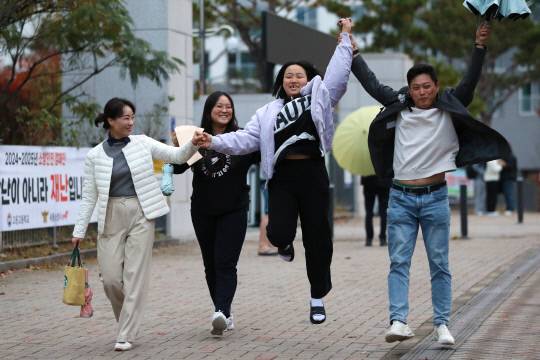 14일 세종시 고운동 고운고등학교 시험장에서 2025학년도 대학수학능력시험을 끝내고 나온 한 수험생이 가족들의 손을 잡고 힘껏 뛰어보고 있다. 김영태 기자
