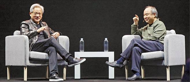 13일 일본 도쿄에서 열린 인공지능(AI) 행사에서 젠슨 황 엔비디아 최고경영자(CEO·왼쪽)와 손정의 소프트뱅크 회장이 대화하고 있다.  /AFP연합뉴스