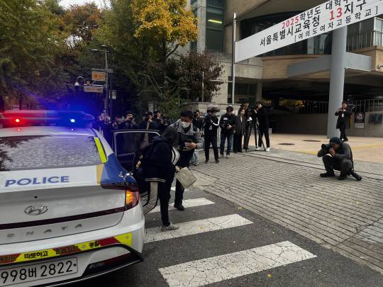 수능 시험장 입실시간 4분 전인 오전 8시 6분쯤 서울 영등포구 여의도여고 앞에 지각을 우려해 경찰에 도움을 청한 한 수험생이 급하게 차에서 내려 시험장으로 향하고 있다. 이시영 기자