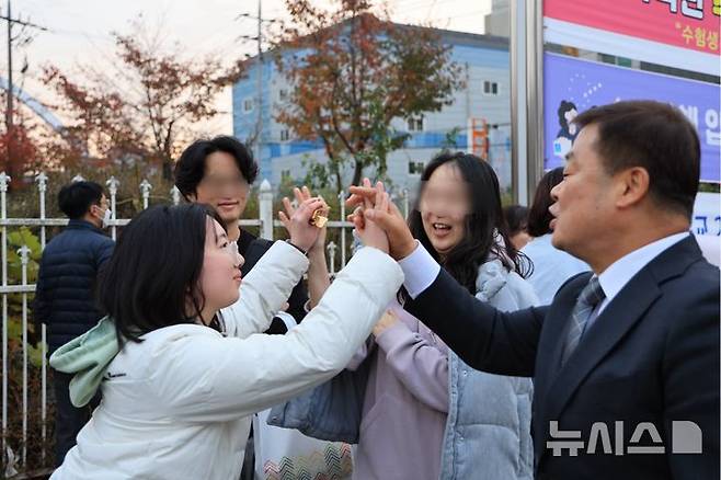 [천안=뉴시스] 박우경 기자 = 충남 천안교육지원청 이병도(오른쪽)지원장이 14일 2025학년도 대학수학능력시험이 치러지는 충남교육청 60지구 제11시험장인 북일여자고등학교에서 수험생을 응원하고 있다. 2024.11.14 spacedust1@newsis.com