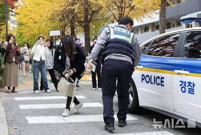 [서울=뉴시스] 황준선 기자 = 2025학년도 대학수학능력시험일인 14일 오전 서울 영등포구 여의도여자고등학교에서 한 수험생이 경찰차를 통해 시험장에 도착하며 감사인사를 하고 있다. 2024.11.14. hwang@newsis.com