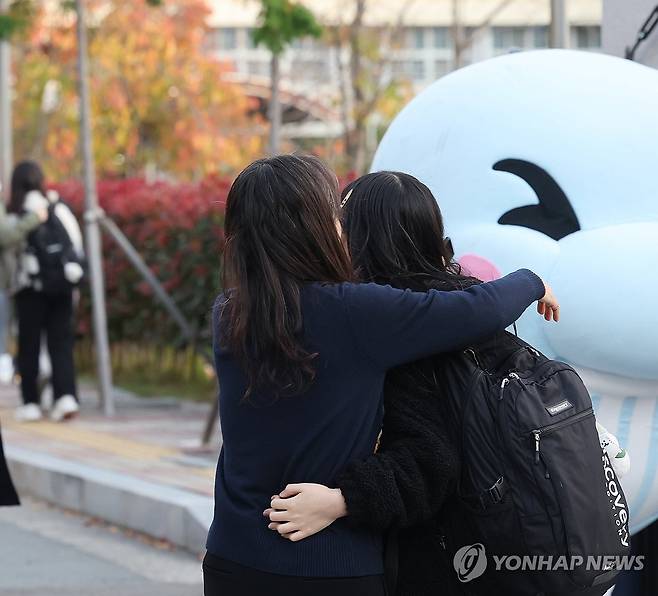 따뜻한 응원 (울산=연합뉴스) 김용태 기자 = 2025학년도 대학수학능력시험일인 14일 오전 울산시 남구 울산여고 앞에서 한 수험생이 입실 전 가족과 끌어안으며 격려받고 있다. 2024.11.14 yongtae@yna.co.kr