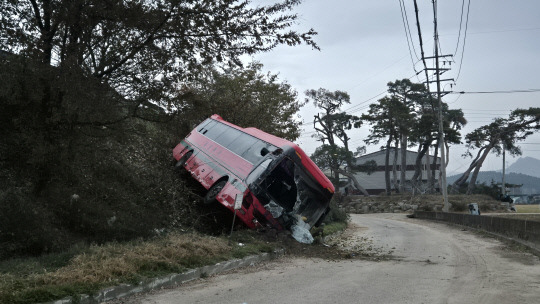 대전통영고속도로 금산ic 인근에서 한국타이어 통근버스가 빗길에 미끄러져 반대편 18t 화물차와 충 충돌하고 난간을 벗어나 언덕 아래로 미끄러져 있는 모습 .금산소방서 제공