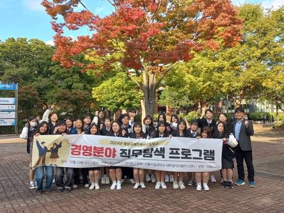 UOS Outreach 경영 분야 직무탐색 프로그램에 참여한 해성국제컨벤션고 학생들이 서울시립대 교정에서 기념 촬영하고 있다.