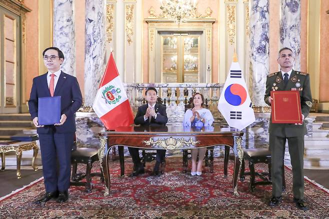 Hyundai Rotem President Lee Yong-bae (far left) and Jorge Zapata (right), CEO of Peru’s Army Weapons and Ammunition Factory, pose at a partnership signing ceremony in Lima, Peru on Saturday, with President Yoon Suk Yeol (second from left) and his Peruvian counterpart Dina Boluarte in attendance. (Presidential office)