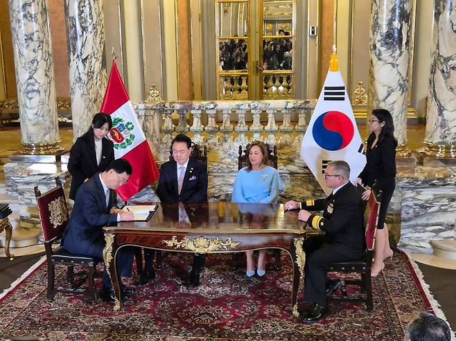 Far left, Joo Won-ho, head of HD Hyundai Heavy Industries' (HHI) naval and special ship business unit; and SIMA General Manager César Augusto Benavides Iraola, far right, sign a memorandum of understanding for joint submarine development with Korean President Yoon Suk Yeol and Peruvian President Dina Boluarte in attendance at the Presidential Palace in Lima on Saturday. [HD HYUNDAI HEAVY INDUSTRIES]