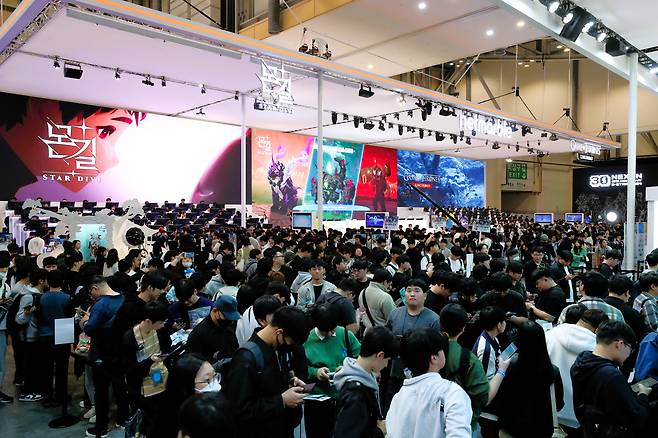 14일 오전 부산 해운대구 벡스코에서 열린 국제게임전시회 '지스타 2024'를 찾은 관람객들이 부스를 둘러보며 게임을 하고 있다./김동환 기자