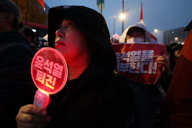 거부권을 거부하는 전국비상행동 등 시민단체 주최로 16일 오후 서울 종로구 광화문 광장 일대에서 열린 \'김건희 특검 수용, 국정농단 규명! 윤석열을 거부한다 시민행진\' 집회에서 참석자가 `윤석열 퇴진\'이라고 적힌 엘이디 전등을 흔들고 있다. 김영원 기자 forever@hani.co.kr