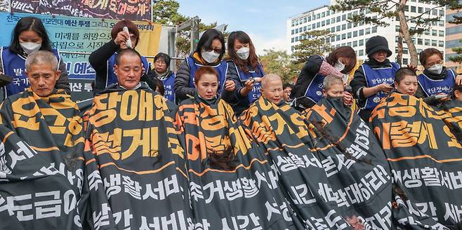 19일 서울 여의도 국회 앞에서 2025 발달장애 예산확대 투쟁 전국장애인부모연대 삭발투쟁선포 및 전국결의대회에서 중앙이사단 등 학부모들이 삭발을 하고 있다.
