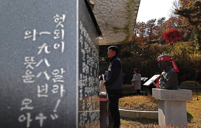 양경수 민주노총 위원장이 인사말을 통해 “윤석열 정권은 변화의 시기에 퇴행의 폭주 기관차가 돼 우리 사회를 망가뜨리고 있다”며 “전태일 열사의 외침이 노동자 민중에게 저항의 불씨가 됐듯, 윤 정권의 퇴진과 한국 사회 대전환의 계기가 돼야 한다는 막중한 책임감으로 하루하루 싸워나가겠다”고 밝히고 있다. 왼쪽으로 ‘내 죽음을 헛되이 말라’ 등이 새겨진 비석이 있다.