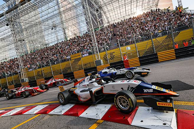 리스보아 밴드 스탠드의 수 많은 관람객들과 코너를 파고드는 포뮬러 레이스카들. 사진 마카오 GP