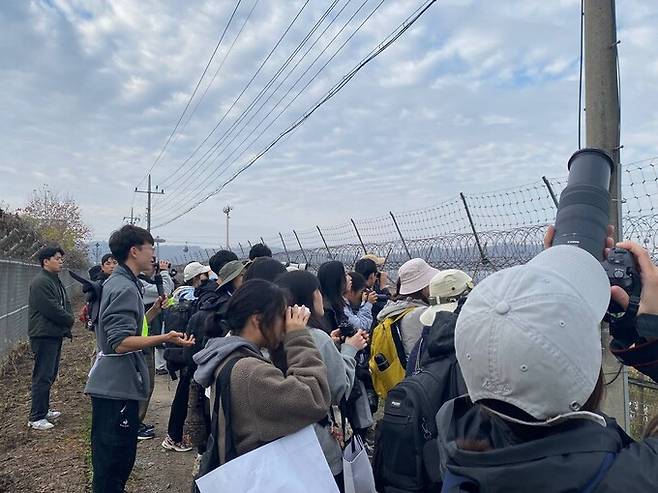 지난 15일 민간인통제구역인 경기도 파주시 임진강변 생태탐방로에서 동영상 크리에이터 ‘새덕후’ 김어진씨(왼쪽 두 번째 회색 옷)가 시민 50여 명이 참여하는 야생 조류 탐조 프로그램을 진행하고 있다. 경기광관공사 제공