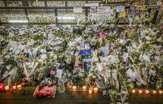 Bundles of white chrysanthemums are left at Exit 1 of Itaewon Station in Yongsan District, central Seoul, on Nov. 3, 2022, after the crowd crush tragedy claimed 159 lives on the night of Oct. 29. [CHOI YEONG-JAE]