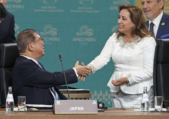 15일 APEC 정상회의 때 앉아서 페루 대통령과 악수하는 이시바(왼쪽) 일본 총리 [교도 연합뉴스. 재판매 및 DB 금지]