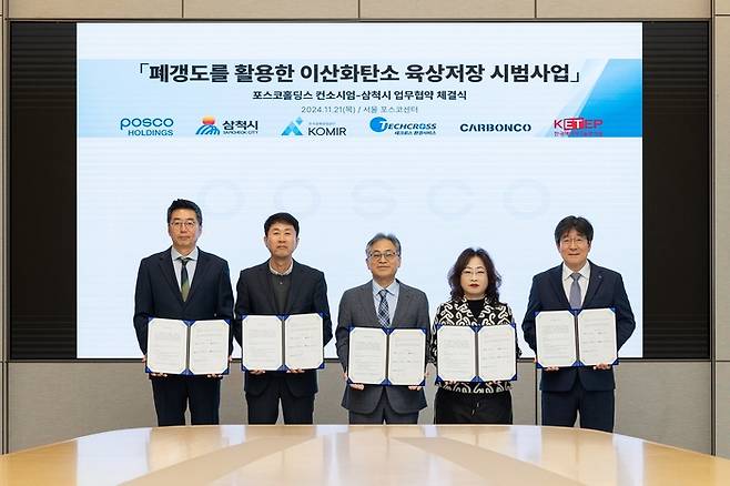 고현신 카본코 최고기술책임자(CTO)와 조인성 삼척시 경제진흥국장, 한건우 포스코홀딩스 저탄소CCUS연구센터장, 이진수 한국광해광업공단 기술연구원장, 김상민 테크로스환경서비스 신사업본부장(왼쪽부터)이 지난 21일 폐갱도를 활용한 이산화탄소 육상 저장 시범 사업을 위한 협약을 맺은 뒤 기념촬영을 하고 있다. DL이앤씨