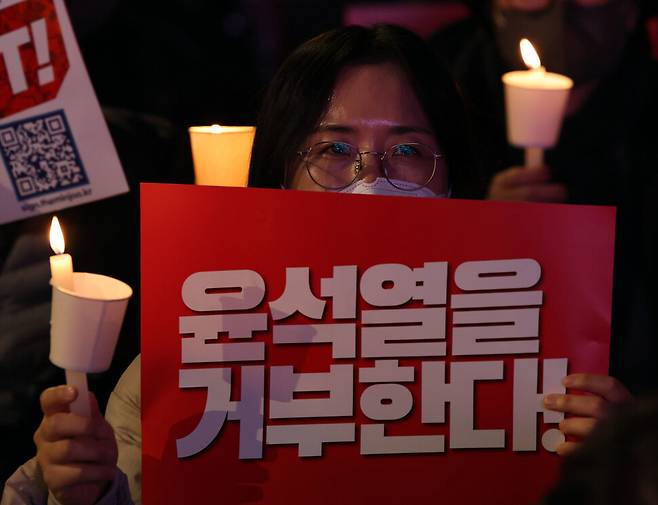 한 시민이 촛불과 손팻말을 들고 있다. 김태형 기자