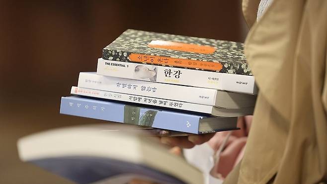 서울 종로구 교보문고 광화문점에서 한 시민이 노벨문학상을 수상한 소설가 한강의 책을 구매하고 있다/사진=연합뉴스