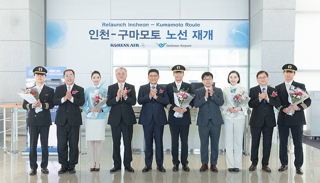 황성원 대한항공 여객노선부 담당(왼쪽에서  다섯 번째), 히사모토 마사노리 구마모토국제공항 주식회사 영업본부장(왼쪽에서 네 번째) 등 주요 관계자들이 KE777편 운항·객실 승무원들과 기념사진을 촬영하고 있다. [대한항공 제공]