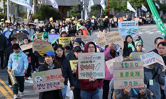 부산 벡스코에서 25일부터 시작하는 국제 플라스틱 협약 제5차 협상회의(INC5)를 앞두고 지난 24일 부산 해운대해수욕장에서 16개 환경단체로 구성된 '플뿌리연대'(플라스틱 문제를 뿌리 뽑는 연대) 회원들이 부산 해운대 해수욕장 일대를 행진하고 있다. 연합뉴스