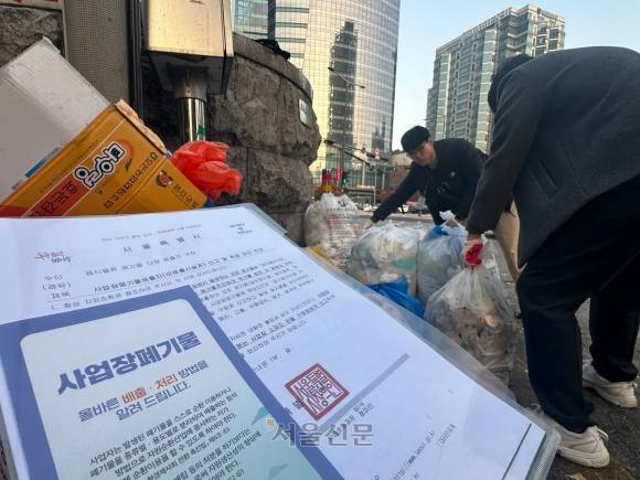 지난 21일 오후 서울 서대문구 일대에 있는 폐기물 배출 의심 사업장을 대상으로 현장 점검에 나선 최용진(앞) 서울시 자원순환과 주무관과 김태민 서대문구 청소행정과 주무관이 길거리에 있는 폐기물을 살펴보고 있다.