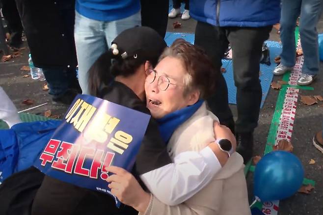 25일 오후 서울 서초구 서울중앙지방법원 앞에서 이재명 더불어민주당 대표의 지지자들이 이 대표의 위증교사 혐의 관련 1심 재판 무죄 선고 소식에 얼싸안으며 기뻐하고 있다. /뉴스1