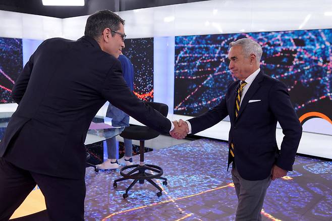 지난 13일 루마니아 대선 후보 TV 토론장에서 진행자와 악수하고 있는 무소속 컬린 제오르제스쿠(오른쪽) 후보. 지난달 여론조사에선 지지율이 6순위에 그쳤던 그가 25일 1차 투표 결과 깜짝 1위로 결선에 진출했다. /로이터 연합뉴스